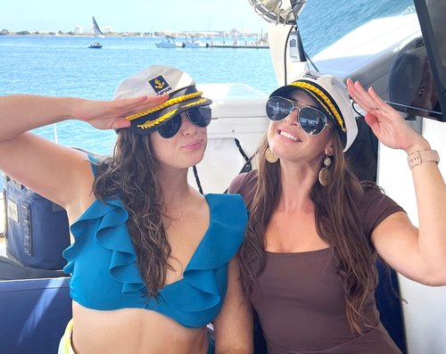 Friends wearing captain hats aboard the boat