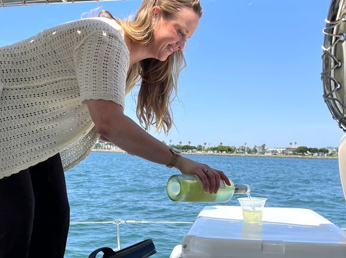Guest pouring drinks during a BYOB catamaran charter